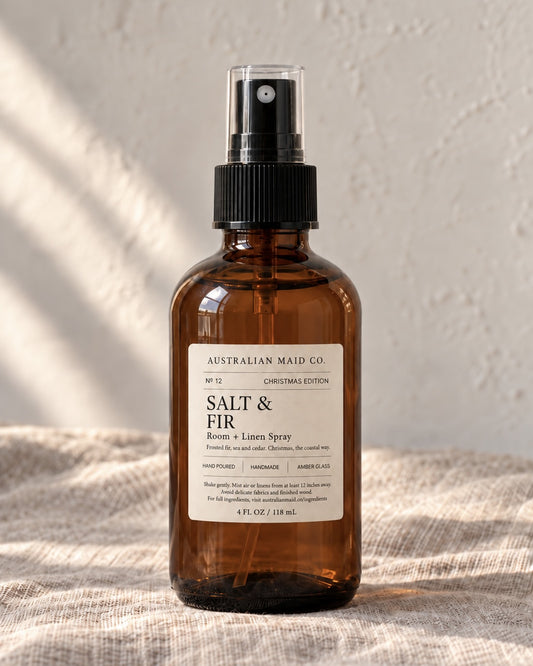 Salt & Fir Christmas Edition room and linen spray in an amber glass bottle on natural linen